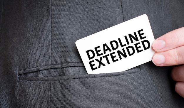 Card with DEADLINE EXTENDED text in pocket of businessman suit Investment and decisions business concept