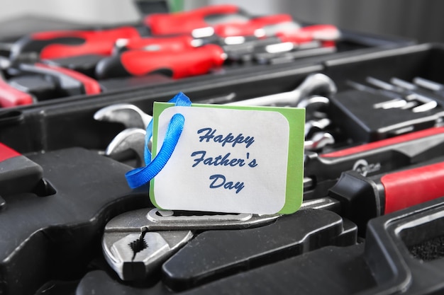 Photo card with text happy father's day and set of tools in box closeup