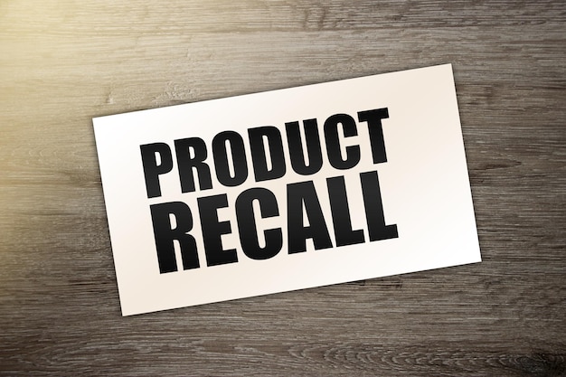 Card with text PRODUCT RECALL on wooden background business concept