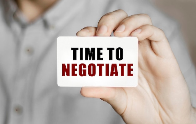 텍스트가 있는 카드 TIME TO NEGOTIATE 남자의 손에