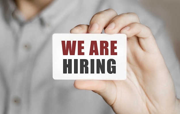 Card with text We are hiring in a man's hand