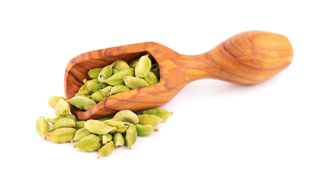 Cardamom seeds in wooden scoop isolated