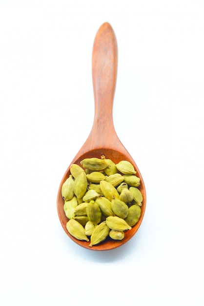 Cardamom Seeds in Wooden Spoon on White background