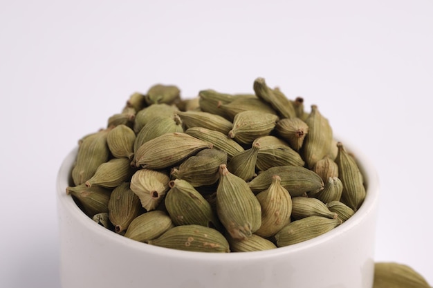 Cardamomindian spicemain ingrediant of indian cuisines arranged on awhite textured background