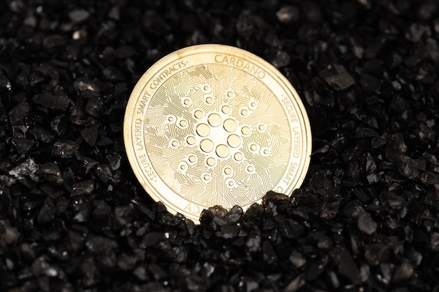 Photo cardano coin on black gravel background cryptocurrency blockchain money