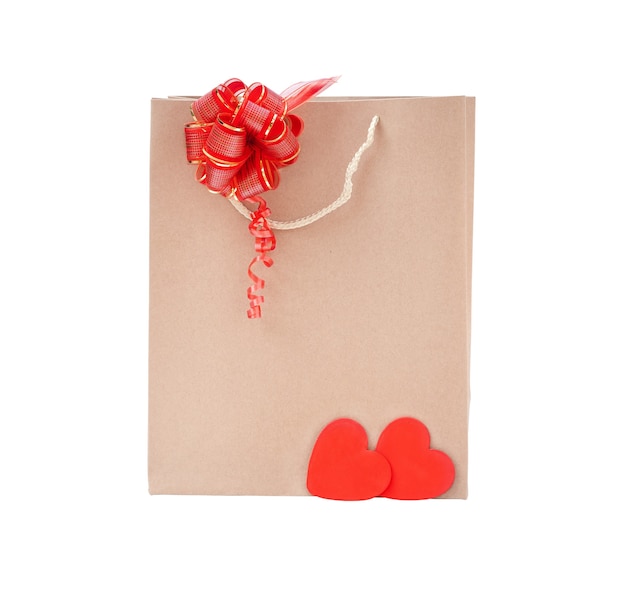 Фото Картонный пакет с бантом изолятором. эко-пакет с красным бантом и красным сердцем на белом фоне