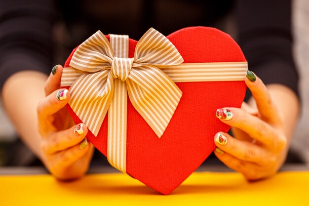 Cardboard biodegradable heart-shaped gift box in women's hands