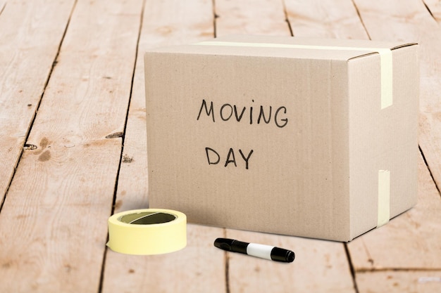 Картонная коробка с надписью "День переезда" на полу