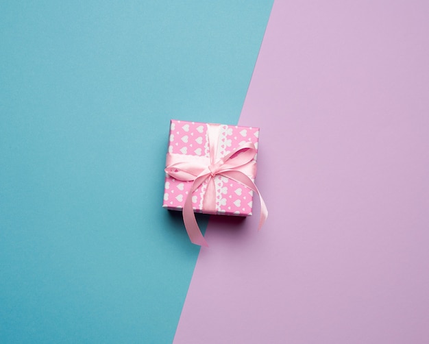 Cardboard box and pink ribbon with bow