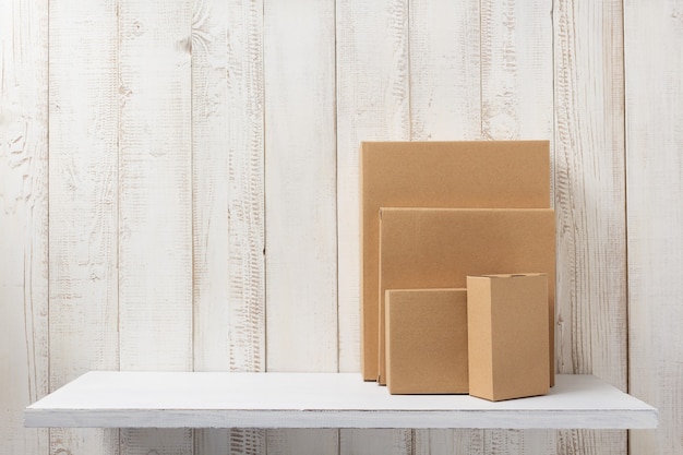 Cardboard box on white wooden shelf
