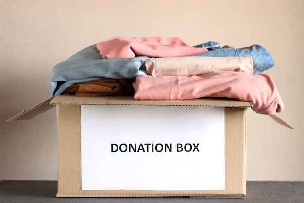 Cardboard box with donations with clothes closeup