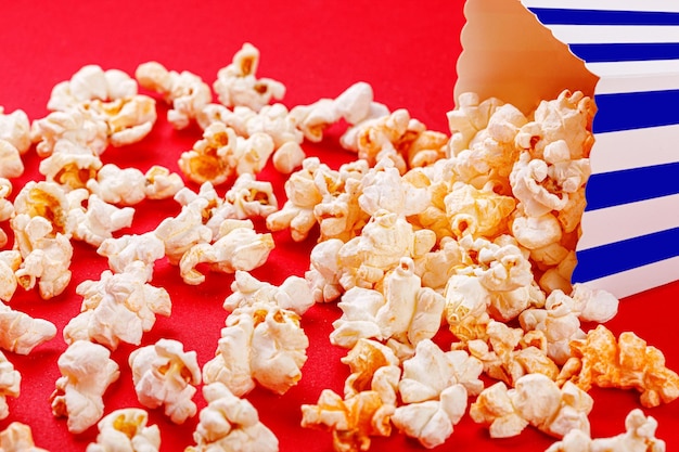 Photo cardboard box with popcorn on a red background closeup