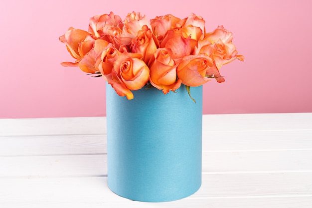 Cardboard box with roses on pink surface