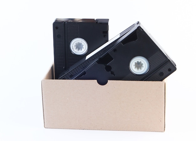 Scatola di cartone con videocassette su un bianco