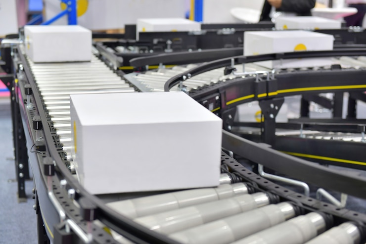 Photo cardboard boxes on conveyor belt in distribution warehouse.parcels transportation system concept.