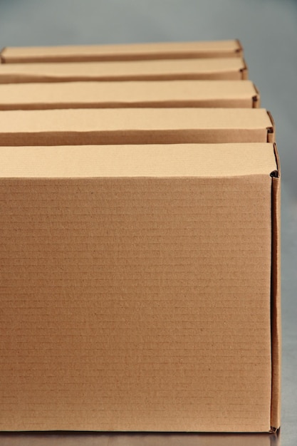 Cardboard boxes on conveyor belt on grey background