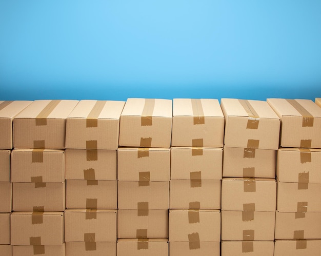 Cardboard boxes for delivery or moving Stack of boxes and blue background Copy space for text