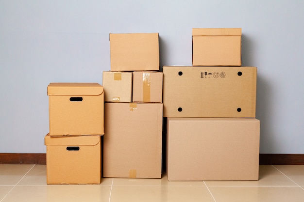 Cardboard boxes for moving on the floor against grey wall