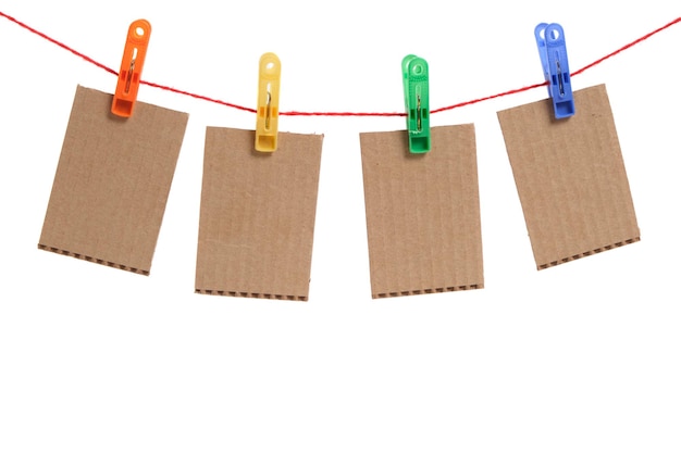 Cardboard cards are hung by clothespins on a white background.Template for the inscription.