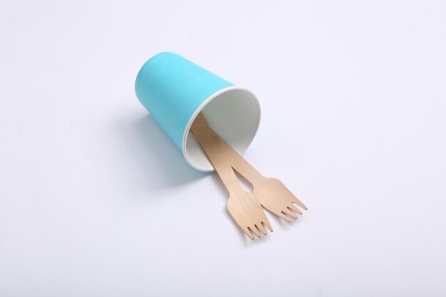 Cardboard cup with wooden forks on a white background Eco concept