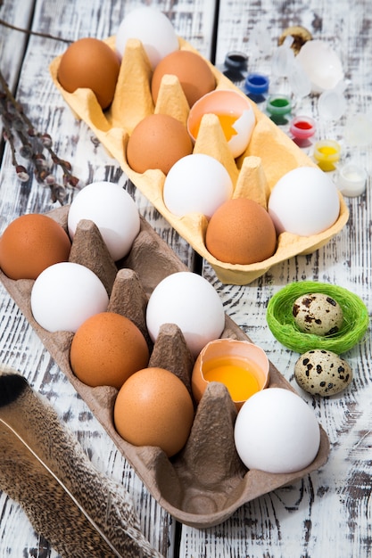 Cardboard egg box on wooden table. Easter still life