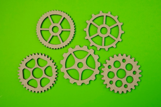 Cardboard gears handmade symbol support or service on green paper background