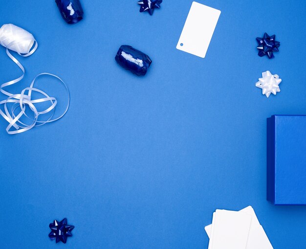 Cardboard gift square boxes, bows and ribbons for packaging on a dark blue surface