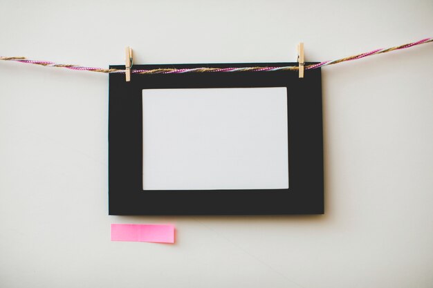 Cardboard photo frame and sticky note on white background