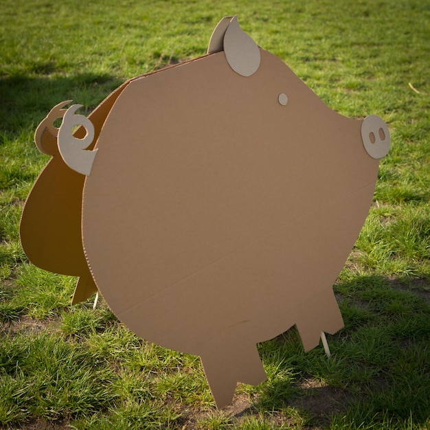 Cardboard pig on a green grass Creative decoration