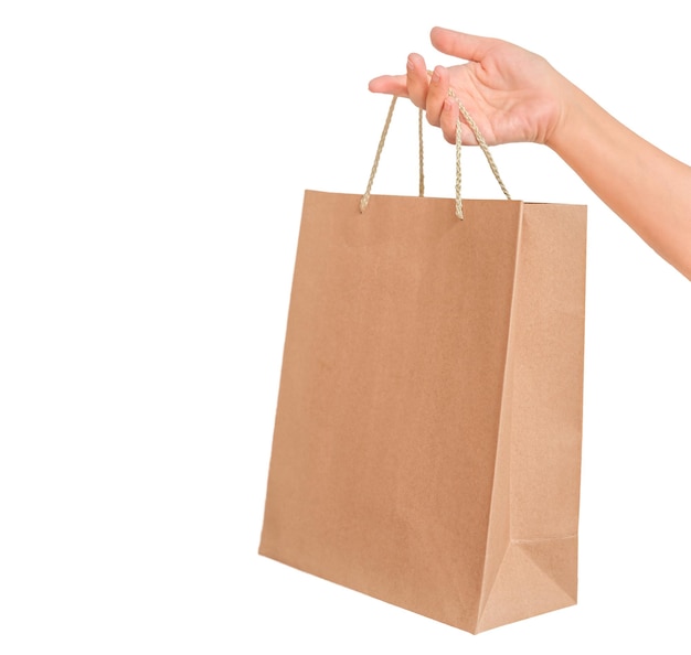 Cardboard shopping bag in female hand isolated on white background