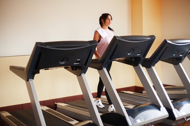 Foto allenamento cardio donne in forma in esecuzione su tapis roulant facendo allenamento cardio in una palestra, concetto di stile di vita sano