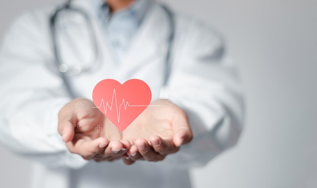 Cardioloog dokter die het hartslagpictogram vasthoudt voor het controleren van de functie van het hart van de patiënt medische check-up hartaanval cardiologie hulp van een specialist
