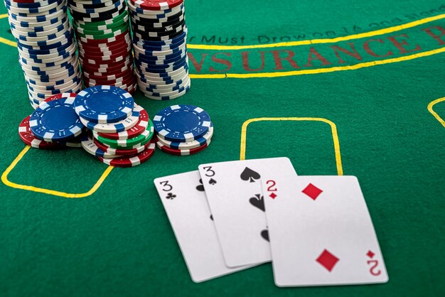 The cards are arranged next to colored chips that stand in\
columns on a green poker table. poker concept