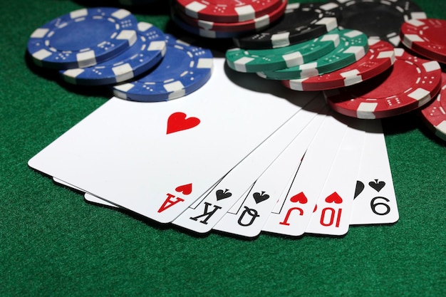 Cards and chips for poker on green table