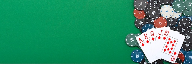 Cards and poker chips on a green background.