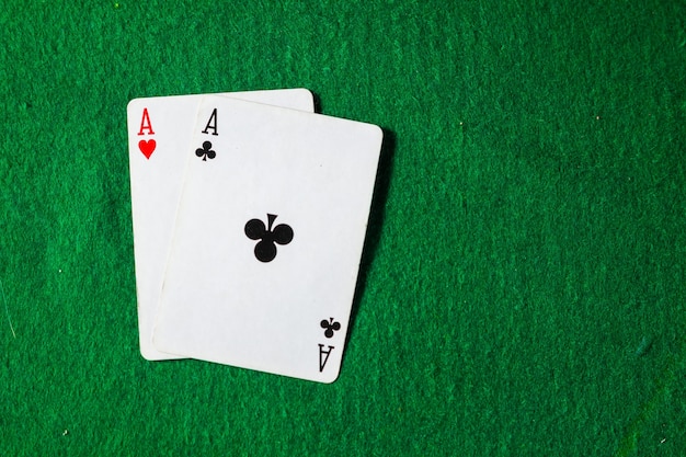 Cards in poker, two aces on green surface with copy space