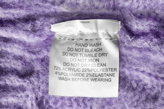 Care and composition clothes label on purple knitted background