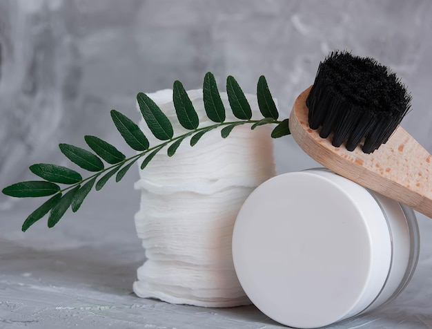 Care cosmetics on a gray background, a white jar of hair balm, a white jar of face cream