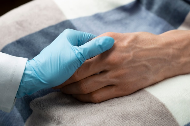 Care of the doctor for the patient. Hands of an old woman in the arms of a nurse. Service and support for the elderly.