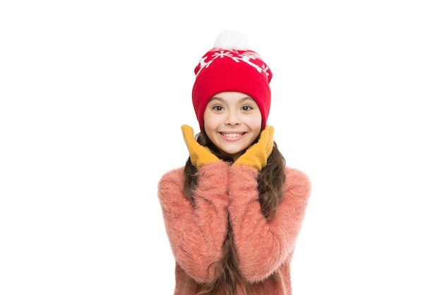 ニットウェアのお手入れ。ニット帽と手袋の小さな女の子。クリスマスの休日の活動。白で隔離の子供居心地の良いセーター。寒い冬の天気。子供のための暖かい服とアクセサリーのファッション。幸せな子供時代。