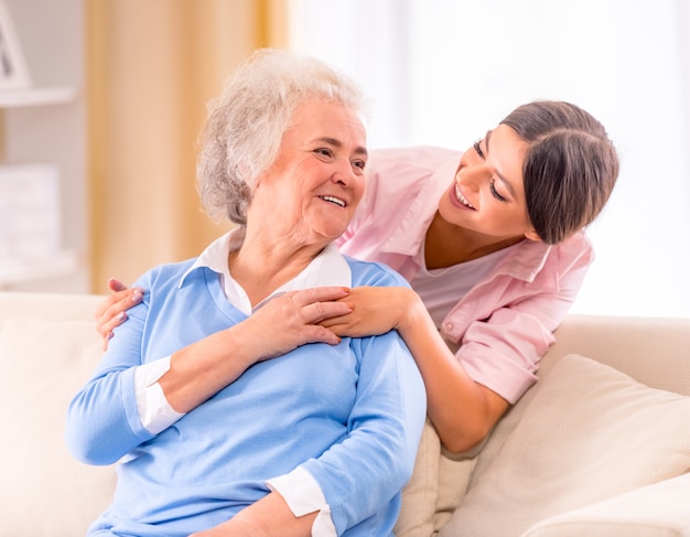 Care of senior woman at home sitting on the couch