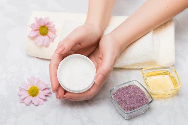 Photo care for women's hands with baths with sea salt and oil treatment. in the hands of a scrub