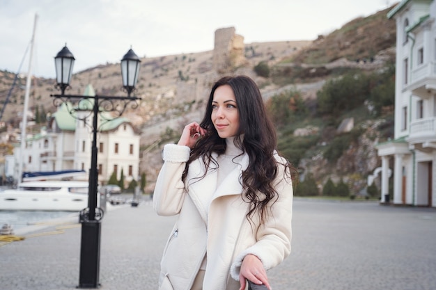 Carefree caucasian woman in beige clothing enjoying the view of the sea