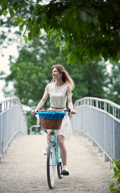 夏の日に楽しんで公園で青い自転車に乗ってのんきな女の子