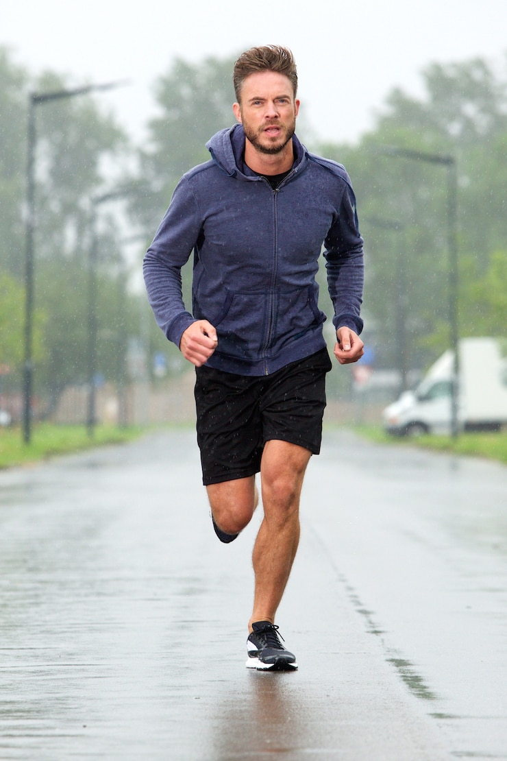 Photo carefree older runner in middle of street