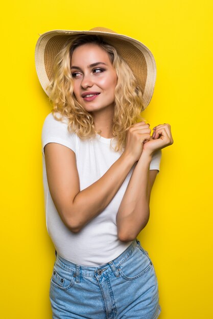 Carefree summer. Beautiful summer girl in on yellow wall.