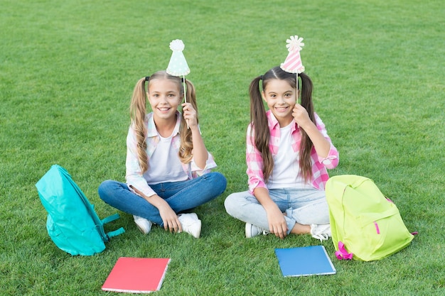 Carefree time together. happy childrens day. sisterhood and family concept. knowledge day came. have fun with party attribute. two little kids with backpack. small girl play and study on school break.