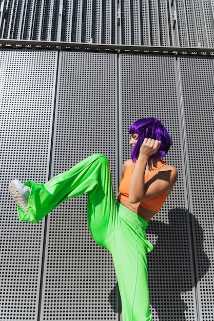 Photo carefree woman dancer wearing colorful sportswear having fun on the street during summer sunny day