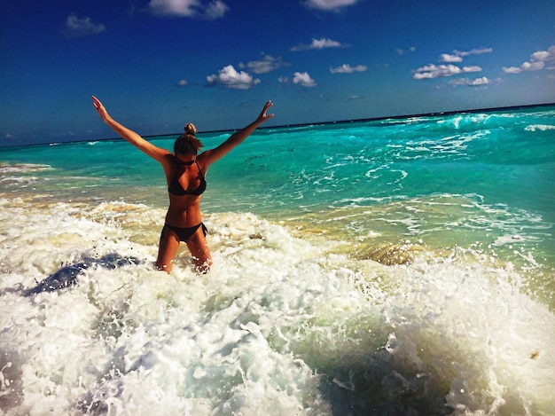 写真 空に向かって海を楽しむ無関心な若い女性