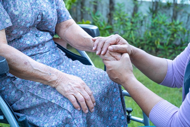 Caregiber hand in hand Aziatische senior of oudere oude dame vrouw patiënt met liefde, zorg, aanmoedigen en empathie op verpleegafdeling ziekenhuis, gezond sterk medisch concept